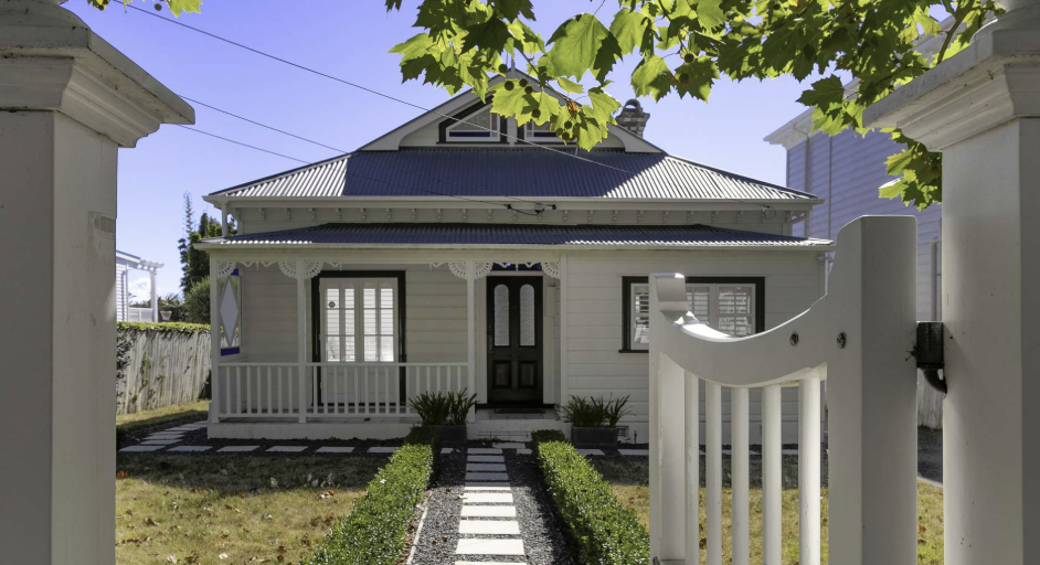 The heritage villa at 18 Herne Bay Road, Auckland, viewed through its garden gate